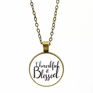 Close-up of bronze alloy necklace with Thankful & Blessed lettering on white background