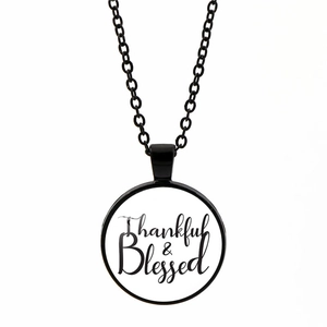 Detail of round pendant necklace featuring Thankful & Blessed cursive text engraving