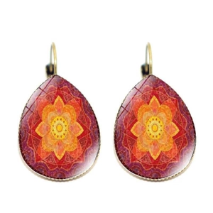 Macro view of teardrop earrings featuring intricate orange and red mandala patterns