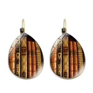 Macro detail of teardrop library earrings featuring vintage book spines in bronze frames