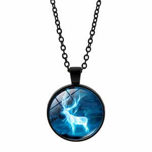 Détail de la chaîne en métal noir et pendentif en verre avec motif de cerf blanc lumineux