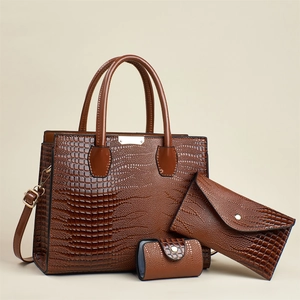Detailed view of 3-piece dark brown lizard-texture tote set with golden hardware
