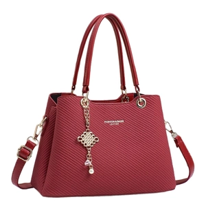 Elegant red embossed leather handbag with double handles and decorative tassel