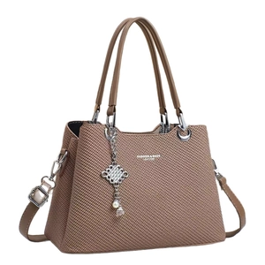 Brown woven texture tote bag with dual handles, crossbody strap and pearl charm accent