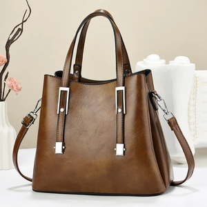 Detailed close-up of brown leather handbag texture with silver metal buckles