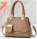 Close-up of khaki tote bag featuring diagonal quilting details and mini purse charm
