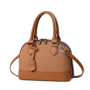 Brown shell-shaped handbag with woven texture and leather details on white background
