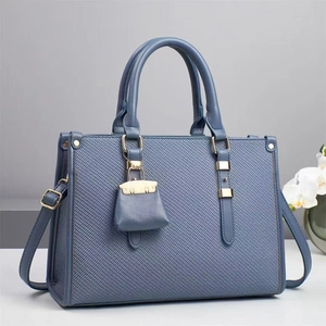Elegant grey-blue canvas bucket bag with leather handles and mini matching pouch