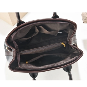 Detailed interior of a dark brown tote bag with multi-compartment zip storage