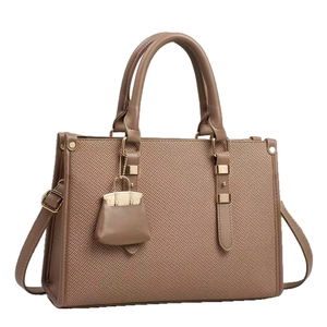 Brown woven tote bag with smooth leather trim, golden hardware and mini bag charm