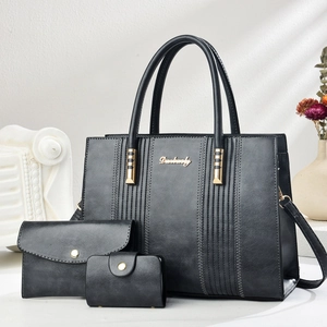 Close-up of three-piece black PU leather handbag set with tote, clutch and coin purse