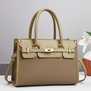 Detailed view of luxury tote with gold twist lock and litchi texture leather finish