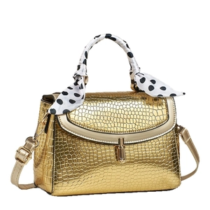 Golden crocodile pattern handbag with polka dot silk scarf handle and adjustable strap