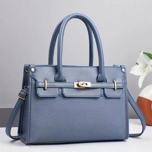 Blue textured canvas and leather tote bag with gold metal buckle and lily floral decor