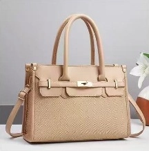 Detailed view of beige woven tote bag with golden lock and adjustable strap