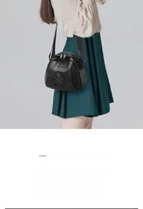 Vue détaillée du sac bandoulière noir en tissu Oxford porté par un mannequin
