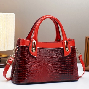 Elegant red crocodile embossed patent leather handbag with gold hardware and shoulder strap
