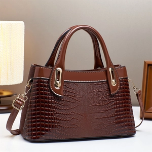 Elegant brown crocodile pattern handbag with gold hardware and adjustable strap