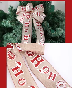 Detail of Christmas ribbon with HO HO HO print and festive bow on a tree