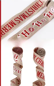 Detail of 6.5cm wide burlap Christmas ribbon with glittery Merry Christmas and Ho Ho Ho print