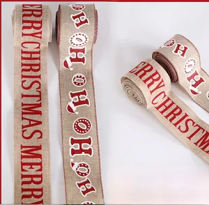 Close-up of burlap Christmas ribbon with red Merry Christmas and Ho Ho Ho print pattern