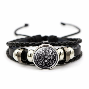 Detailed close-up of multilayer braided leather bracelet with Fire Dept shield charm