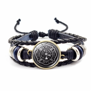 Macro detail of multi-layer firefighter leather bracelet with Fire Dept emblem and blue beads