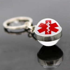 Macro shot of silver medical keychain with Star of Life symbol on reflective surface