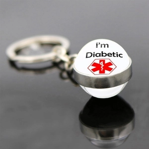 Macro view of Diabetic medical alert glass ball keychain on reflective surface