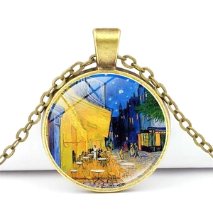 Gros plan du pendentif rond en bronze avec la peinture Café de Nuit de Van Gogh