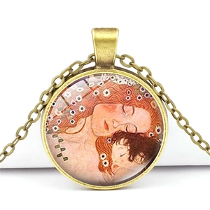 Gros plan du pendentif en bronze vintage avec l'art de Klimt Mère et Enfant sous verre