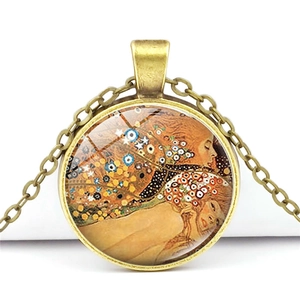 Gros plan détaillé d'un pendentif en bronze vintage avec l'art de Gustav Klimt et chaîne