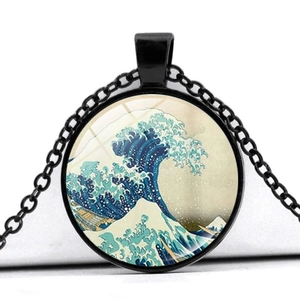 Close-up of circular glass pendant with Great Wave art and black metal chain