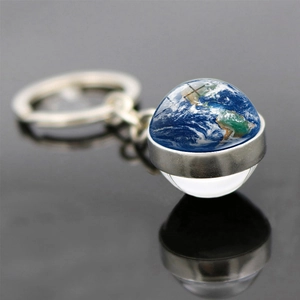 Vista macro del portachiavi con sfera di vetro della Terra e base metallica argentata