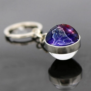 Macro shot of double-sided glass ball keychain with Leo zodiac design and starry background