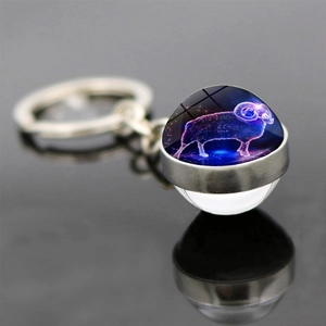 Macro view of Aries constellation luminous glass ball pendant on metal keychain