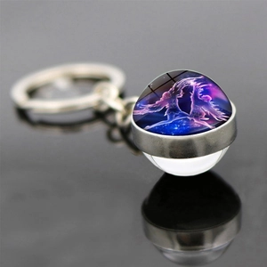 Macro shot of a Gemini zodiac double-sided glass ball keychain with starry night background