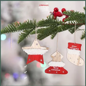 Close-up of four-piece wooden Christmas ornaments with plush trim hanging on pine branches