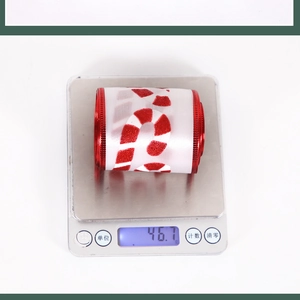 Detail of Christmas ribbon roll with candy cane glitter print and red metallic edges