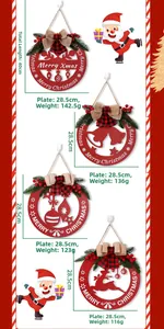 Détail d'une plaque de Noël en bois rouge ajourée avec renne et décor de branches de pin