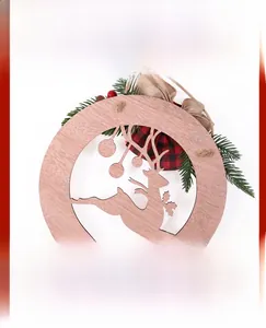Détail d'une plaque de Noël en bois avec renne ajouré, aiguilles de pin et baies rouges