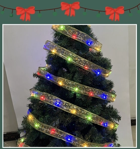 Dettaglio del nastro dorato a LED con motivo a stelle su un albero di Natale verde