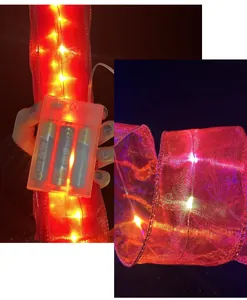 Close-up of red mesh ribbon lights with battery box and warm LED glow for tree decor