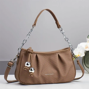 Detail of brown woven cloud bag showing metallic chain strap and gold sphere charms