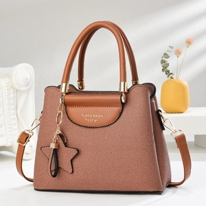 Sac à main en toile marron avec détails en cuir et logo doré au design sophistiqué