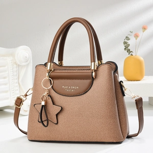 Détail du sac à main en toile tissée marron avec poignées en cuir et boucles dorées