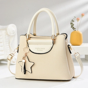 Sac à main chic en toile beige à texture tissée, poignées et breloque étoile à pompon