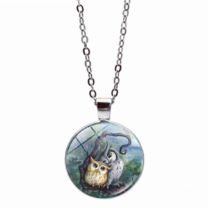 Detailed close-up of a silver owl pendant necklace featuring a glass dome and lobster clasp