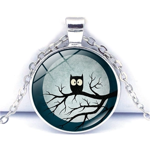 Macro view of silver owl pendant necklace featuring a full moon glass cabochon