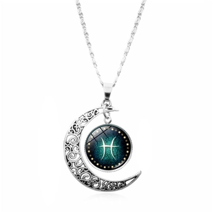 Macro detail of silver hollow moon pendant with Pisces zodiac glass cabochon